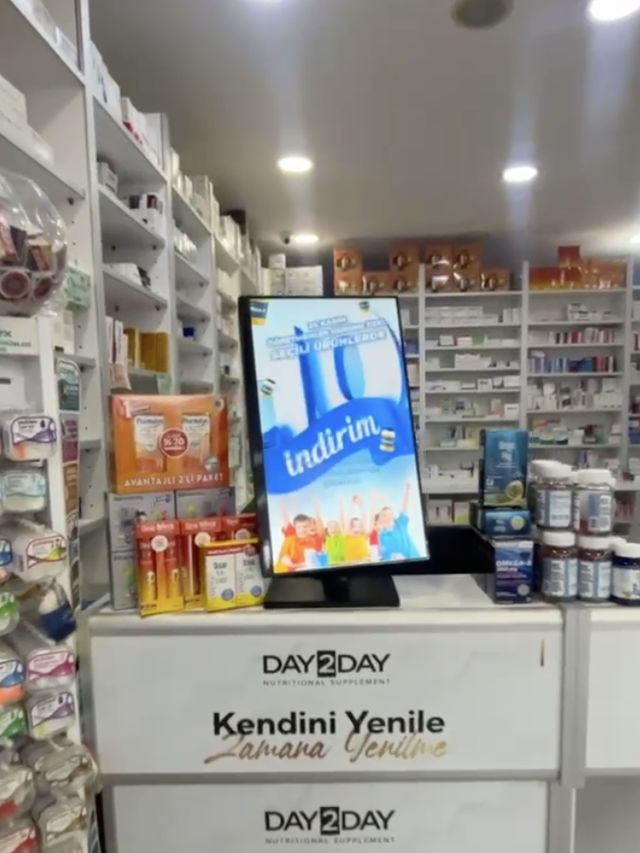 Tezgâh üstünde indirim kampanyası gösteren dikey ekran